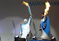 Андрей Бердюгин из Упорово зажигает огонь тюменской чаши Паралимпийского огня. Фото Виктории ЮШЕНКО.